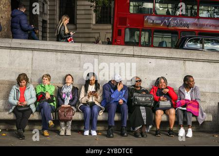 London, Großbritannien. Oktober 2024. Die Leute auf dem Trafalgar Square ruhen sich in der warmen Sonne aus. Nach früherem Nebel und Nebel dominieren Sonnenschein und sehr milde Temperaturen den ganzen Nachmittag im Zentrum von London Credit: Imageplotter/Alamy Live News Stockfoto