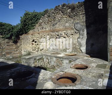 Thermopolium, Via Austali mit Vicolo Storto, Pompeji, Italien, 2002. Kommerzielle Einrichtung, in der verzehrfertige Lebensmittel gekauft werden konnten. Notieren Sie sich die in den Zähler eingestellten Aufbewahrungsbehälter. Die römische Stadt Pompeji (im heutigen Kampanien) wurde während des Ausbruchs des Vesuvs 79 n. Chr. unter vulkanischer Asche und Bimsstein begraben. Stockfoto