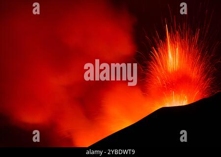 Ätna in Euzione con spattering di Lava dal cratere visto di notte Stockfoto