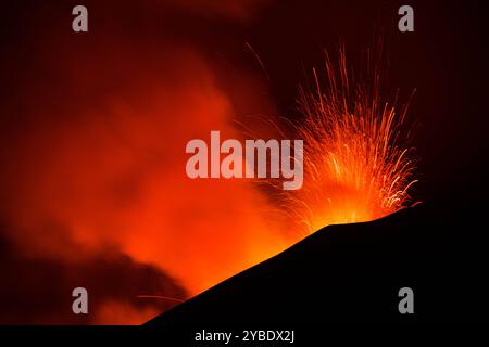 Ätna in Euzione con spattering di Lava dal cratere visto di notte Stockfoto