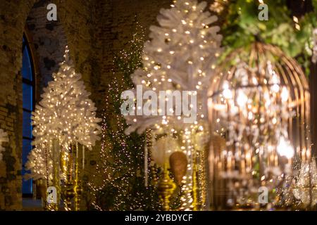 Das Innere eines historischen Veranstaltungsortes ist wunderschön für die Weihnachtszeit dekoriert, mit beleuchteten Bäumen und komplizierten Lichtern Stockfoto