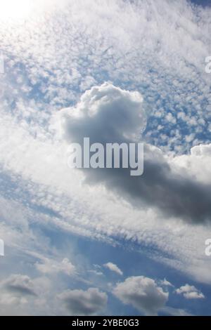 Ein klarer, blauer Himmel mit flauschigen weißen Wolken, die anmutig über ihn gleiten, schafft eine wunderschöne Szene der Ruhe und des Friedens Stockfoto