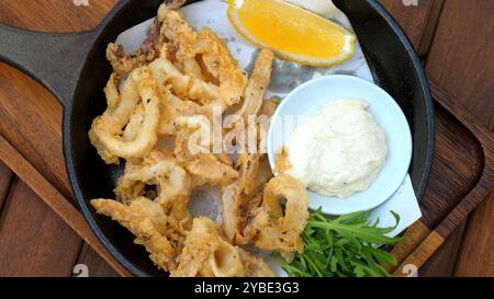 Knusprige Calamari-Ringe serviert mit Zitronenkeil, Dip-Sauce und frisch Stockfoto
