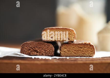 Drei gesunde vegetarische Eiweißschokoladentafeln mit Molkenproteinpulver im Hintergrund Stockfoto