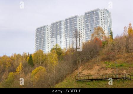 Mehrstöckiges Wohngebäude auf einem Hügel mit Herbstbäumen Stockfoto