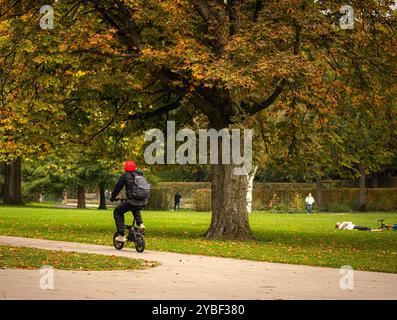 Herbstszenen im Euromast Park, Rotterdam, Niederlande am 18. Oktober 2024 radeln die Menschen unter einem Baum mit leuchtend orangefarbenen Blättern im Euromast Park, umgeben von farbenfroher Herbstlandschaft, Rotterdam, Niederlande. Hedayatullah Amid / Rotterdam Niederlande Copyright: XMatrixxImagesx/xHedayatullahxAmidx Stockfoto