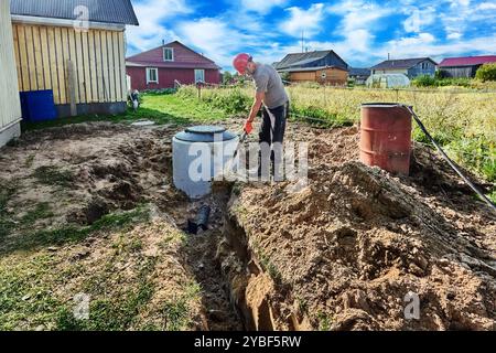 Installation eines Sauggrabens für die Abwasserentsorgung bei der Installation einer autonomen Abwasseranlage mit Klärgrube im ländlichen Raum. Stockfoto