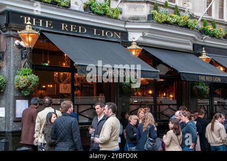 Gäste des historischen Red Lion Pubs treffen sich draußen, um in London zu trinken und zu plaudern Stockfoto