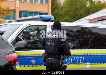 Augsburg, Bayern, Deutschland - 18. Oktober 2024: Ein Polizist der Bereitschaftspolizei steht am Streifenwagen bereit für den nächsten Einsatz, am Berufsinformationstag vom Polizeipräsidium Schwaben Nord in Augsburg *** ein Polizist der Bereitschaftspolizei steht am Streifenwagen bereit für den nächsten Einsatz, am Berufsinformationstag vom Polizeipräsidium Schwaben Nord in Augsburg Stockfoto