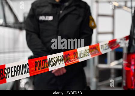 Augsburg, Bayern, Deutschland - 18. Oktober 2024: Ein Polizeibeamter steht hinter einer Polizeibarriere am Karriereinformationstag des Polizeipräsidiums Schwaben Nord in Augsburg *** ein Polizeibeamter steht hinter einer Polizeiabsperrung am Berufsinformationstag vom Polizeipräsidium Schwaben Nord in Augsburg Stockfoto