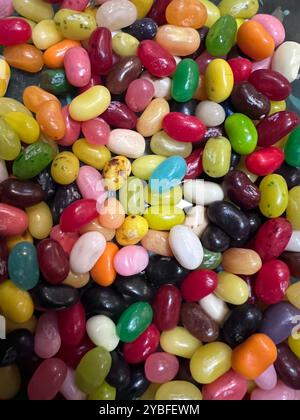 Eine Auswahl an Jelly Beans in einer Vielzahl von Farben füllt den Rahmen und bietet eine köstliche Mischung aus Aromen, die einen Geschmack von Süße und Freude einladen. Stockfoto