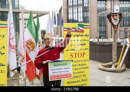 Brüssel, Belgien Oktober 2024. Ein Demonstrant spricht, während er während der Demonstration seine Faust hebt. Auf dem Gipfeltreffen der EU-Staats- und Regierungschefs des Europäischen Rates haben Iraner, Anhänger des Nationalen Widerstandsrates Irans (NCRI), eine Demonstration abgehalten, um die iranische Revolutionsgarde (IRGC) auf der EU-Terrorliste für ihre Rolle bei der Unterdrückung im Iran, der Kriegstreiber und dem Terrorismus im Ausland zu benennen. Quelle: SOPA Images Limited/Alamy Live News Stockfoto