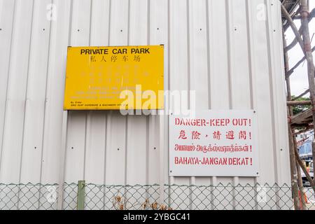 Zweisprachiges Schild für Privatparkplätze - "Danger Keep Out"-Schild in vier Sprachen - Malaiisch, Chinesisch, Thai, Englisch, Singapur Stockfoto