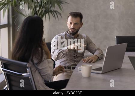 Zwei verschiedene Geschäftsleute, die am Arbeitsplatz sprechen Stockfoto