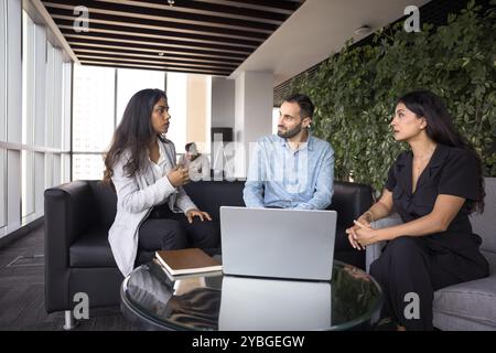 Verschiedene Unternehmensgruppen junger Kollegen, die über Coworking Space sprechen Stockfoto