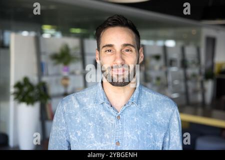 Glücklicher lateinamerikanischer Unternehmer in lässigem Hemd, der in die Kamera schaut Stockfoto