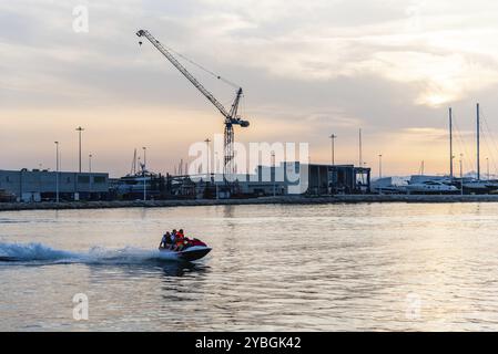 Denia, Spanien, 27. Juni 2019: Malerischer Blick auf die Menschen, die im Hafen der Mittelmeerstadt bei Sonnenuntergang in Europa Jetski fahren Stockfoto