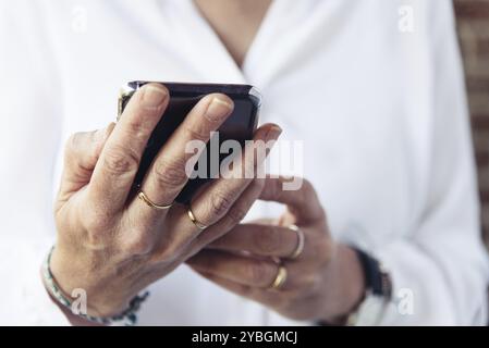 Nahaufnahme der Frauenhand mit Smartphone. Business, Technologie, Kommunikation, Freizeit und Menschen Stockfoto