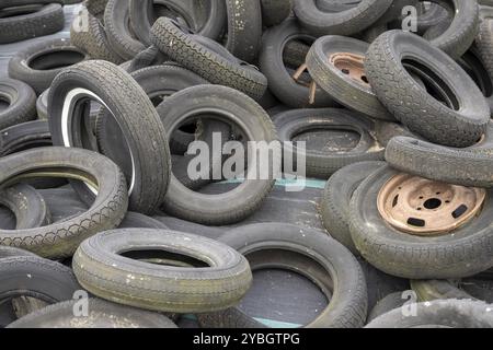 Alte Autoreifen und Felgen in einem großen Haufen in den Niederlanden Stockfoto