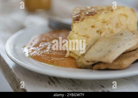 Nahaufnahme eines Tellers mit spanischem Omelette mit Salmorejo, einem typisch andalusischen Essen mit Tomaten Stockfoto