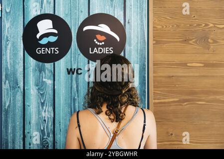 Frau Suchen im Vintage wc Schilder für Damen und Herren auf Holz grüne Tür. Konzept Wahl Stockfoto
