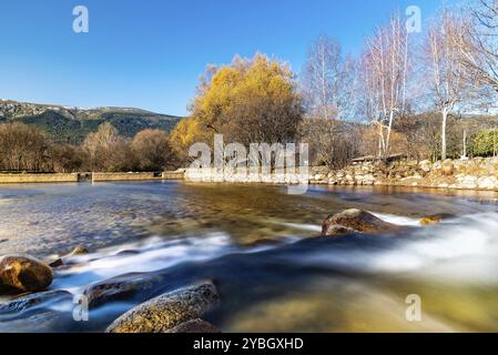 Wasser, das über einen kleinen Damm in Lozoya River in der Nähe von El Paular. Lange Belichtung geschossen mit glatten seidig Wirkung in Wasser Stockfoto