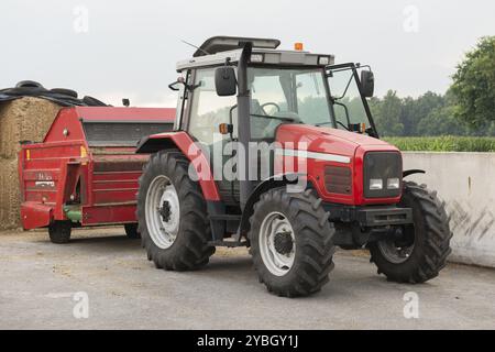 Roter Traktor mit Rotvieh feed Diffusor auf einem Milchviehbetrieb Stockfoto