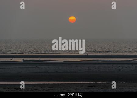 Orangefarbener Sonnenuntergang über der Nordsee vom Strand der Watteninsel Terschelling in den Niederlanden aus gesehen Stockfoto