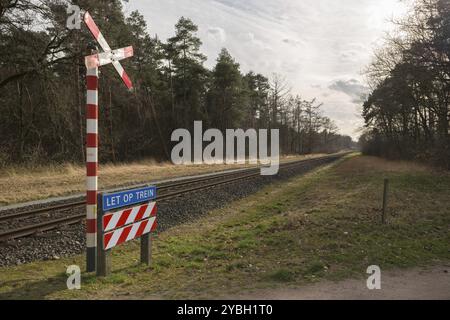 Unbewacht, helle Schiene Eisenbahn überqueren ohne Barrieren und Warnleuchten im Osten der Niederlande Stockfoto