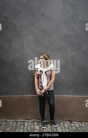 Schöne junge Frau schaut lächelnd gegen die Wand. Konzept Glück und Vertrauen Stockfoto