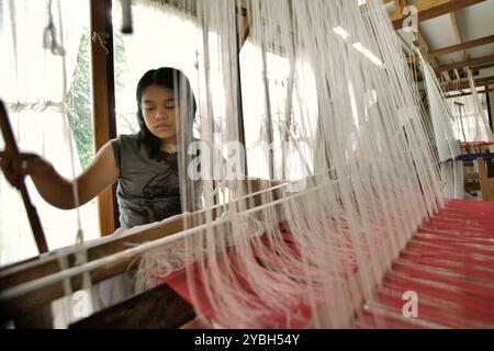 Eine Frau, die im Erika Rianti Songket Studio in Bukittinggi, West Sumatra, Indonesien, traditionelle „Songket“-Stoffe herstellt. Stockfoto