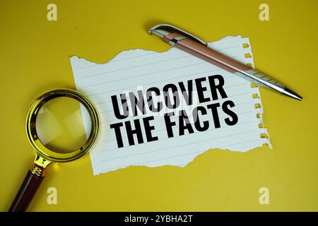 Entdecken Sie die Fakten zitiert Text auf Papier, gerissen mit Lupe von oben auf gelbem Hintergrund Stockfoto