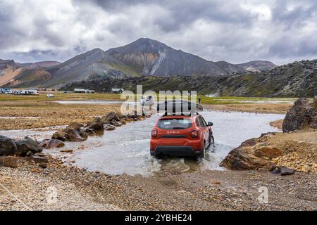 Ein Auto fährt den Fluss entlang, um zum Campingplatz in Landmannalaugar zu kommen Stockfoto