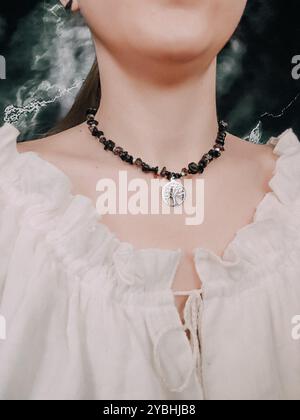 Schwarzer Obsidian-Choker mit Lebensbaum-Anhänger am Hals der Frau Stockfoto