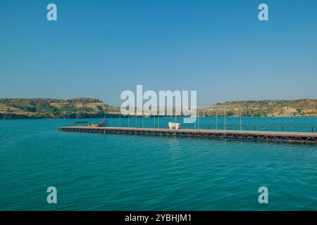 Herrlicher Blick auf den Ponton über das grüne Wasser des Oymapinar Reservoir, vor dem Hintergrund der Taurusberge an einem Sommertag. Stockfoto