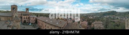 Touristen bewundern an einem bewölkten Tag die malerische Aussicht auf die grünen Hügel rund um das mittelalterliche Dorf Castell'Arquato, Emilia Romagna, Italien Stockfoto