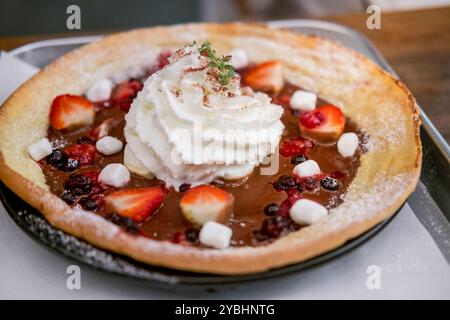 Pfannkuchen mit Schokoladensauce, Marshmellow und Schlagsahne in der Pfanne Stockfoto