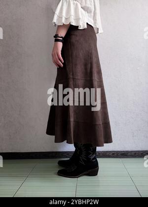 Retro-Outfit, Edler Vintage-Rock Aus Echtem Wildleder, Cowboy-Stiefel, Weiße Böhmische Bluse, Vorderansicht, Outfit-Details, anonyme Frau, Brown A Line Boho Patchwork Midi Rock, Kaffeerock Stockfoto