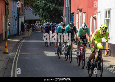 Das Hauptfeld in der sechsten und letzten Etappe der Tour of Britain 2024, die durch Framlingham, eine Marktstadt in Suffolk, führt, während sie zwei Pausen jagen. Stockfoto