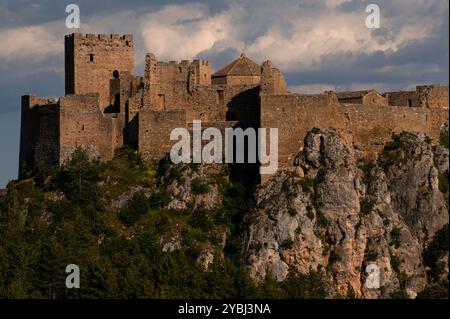 Mittelalterliches Castillo de Loarre in Loarre, Huesca, Aragon, Spanien, von Nordwesten aus gesehen. Auf der linken Seite befindet sich der Gipfel eines rechteckigen, gefechteten Turms, des Torre del Homenaje (Turm der Hommage), und eines quadratischen, gefechteten Turms, des Torre de la Reina (Turm der Königin). Das Zentrum ist die achteckige Kuppel der Inglesia de San Pedro (Peterskirche). Die Burg ist eine romanische Festung, die in den 1000er Jahren in den Ausläufern der Pyrenäen auf einem fast uneinnehmbaren Felsvorsprung etwa 1.070 m (3.510 ft) über dem Meeresspiegel errichtet wurde. Stockfoto