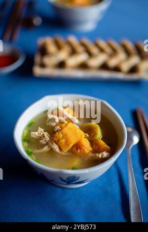 Selektiver Fokus auf heiße Suppe mit Hühnchen und Kürbis, serviert in einer Schüssel. Leckeres Essen in Vietnam. Stockfoto