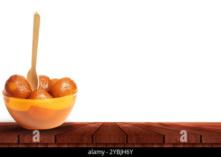 Traditionelles indisches Dessert Gulab Jamun mit Löffel in Schüssel auf Holztisch mit Kopierraum für Diwali-Feier. Stockfoto