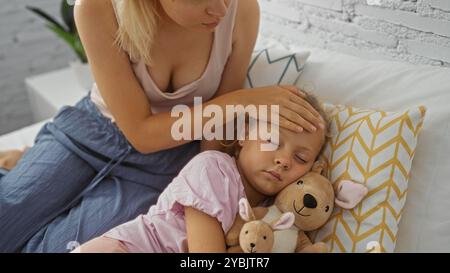 Frau, die sich um eine kranke Tochter im gemütlichen Schlafzimmer kümmert, zeigt Zuneigung und Trost mit dem Kind, das im Bett liegt und ein Kuscheltier hält, während die Mutter sie nach ihr überprüft Stockfoto