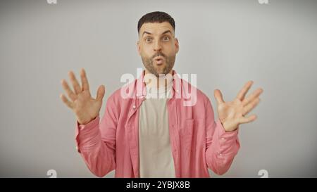 Überraschter junger hispanischer Mann mit Bart auf weißem, isoliertem Hintergrund, der Aufregung ausdrückt. Stockfoto