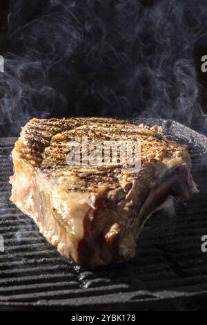 Rauch von einem Rinderkotelett, das auf einem Grill gekocht wird Stockfoto