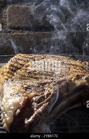 Rauch von einem Rinderkotelett, das auf einem Grill gekocht wird Stockfoto