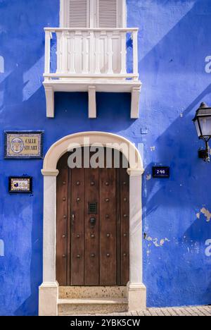 Cartagena de Indias, Kolumbien, 15. Mai 2010: Charmante Colonial Street in Cartagena de Indias mit lebendiger blauer Mauer und Holztür Stockfoto