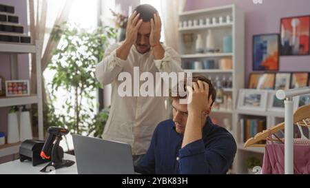 Zwei Männer, die in einem Wohnkultur-Laden gestresst sind, einer stehend und der andere sitzend, umgeben von verschiedenen dekorativen Gegenständen und Möbeln Stockfoto