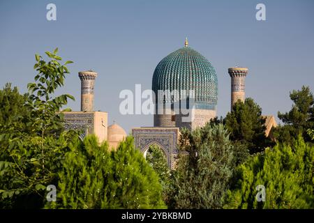 Portal und Kuppel des Gur Amir Mausoleums umgeben von Grün in Samarkand - Usbekistan Stockfoto