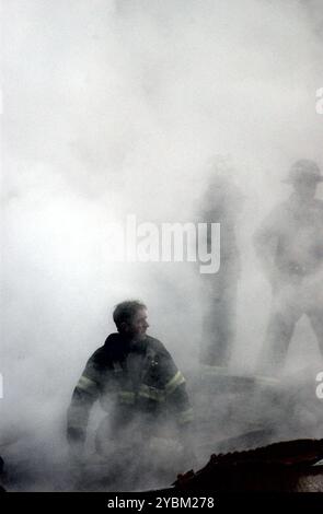 New York, N.Y. (14. September 2001) -- Ein Feuerwehrmann taucht aus dem Rauch und Trümmern des World Trade Center auf. Die Doppeltürme des Zentrums wurden bei einem Terroranschlag vom 11. September zerstört. US Navy Foto von Fotograf 2nd Class Jim Watson. Stockfoto